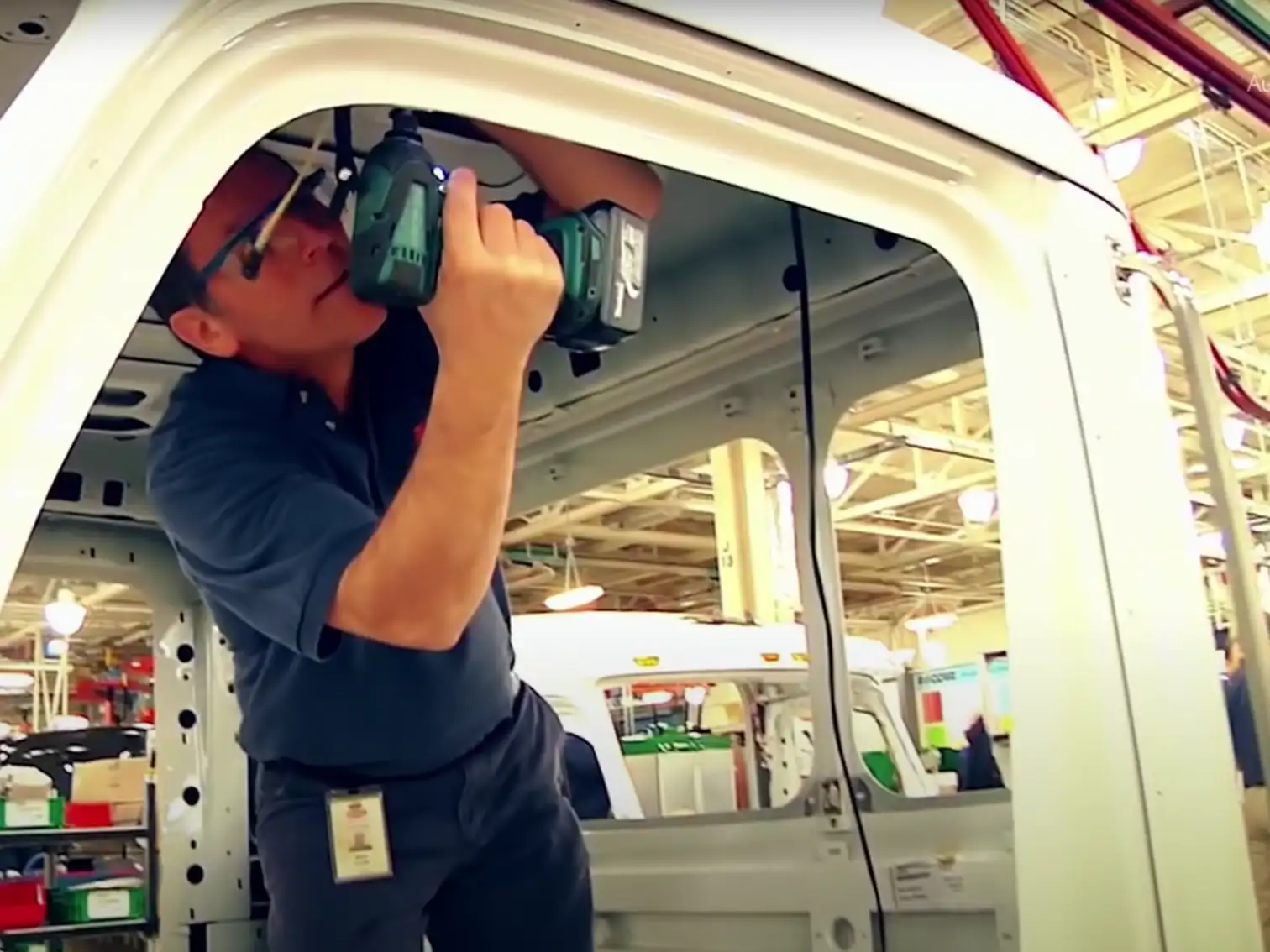 Technician using a drill to assemble a truck